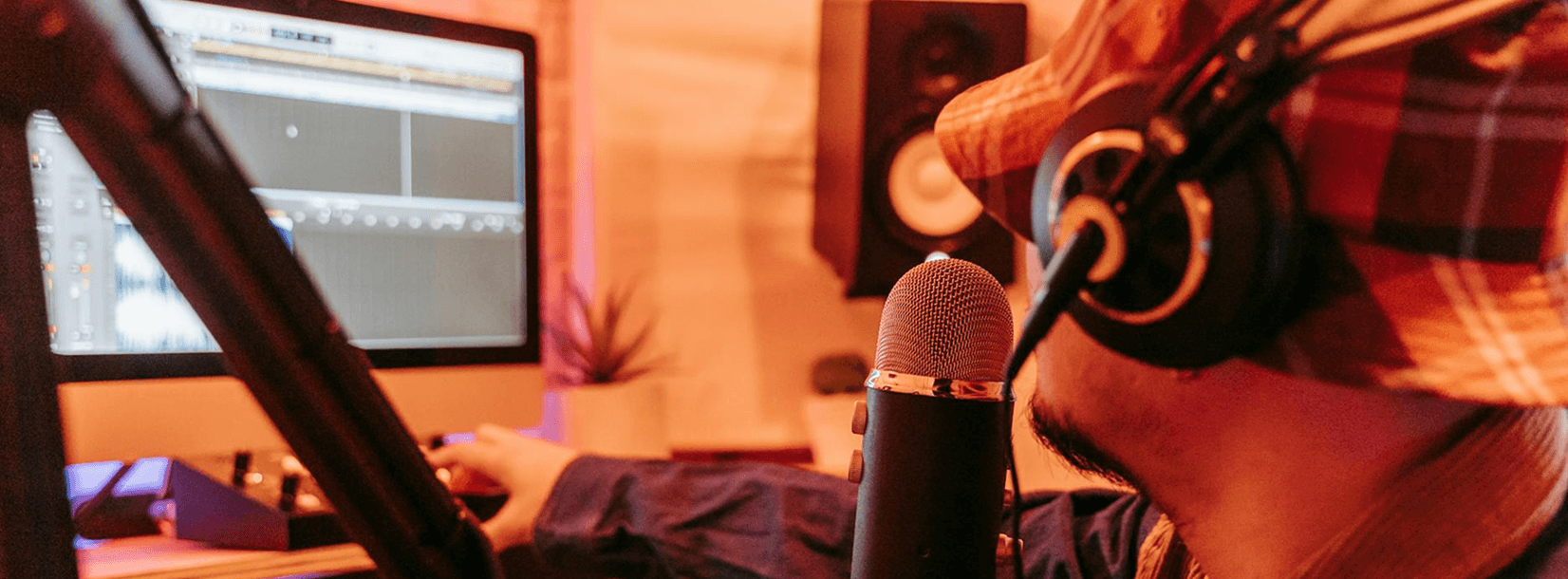 Podcaster recording at a studio setup with microphone and headphones